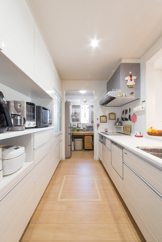 キッチンも白で統一して清潔感を演出。背面収納のほか、奥には家事スペースもあるため使い勝手がいい