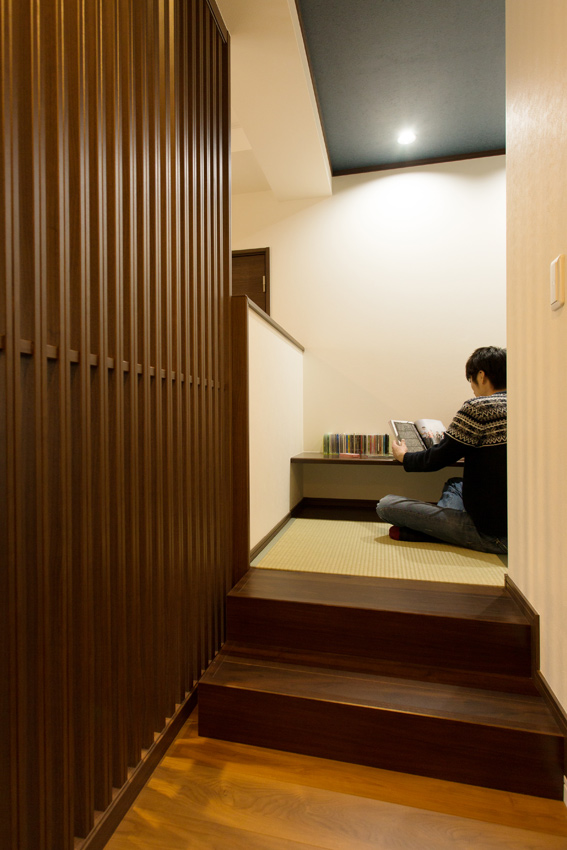 リビングの一角、格子で間仕切りした奥には書斎スペースがある。小上がりの隠れ家空間はおこもり感がたっぷり