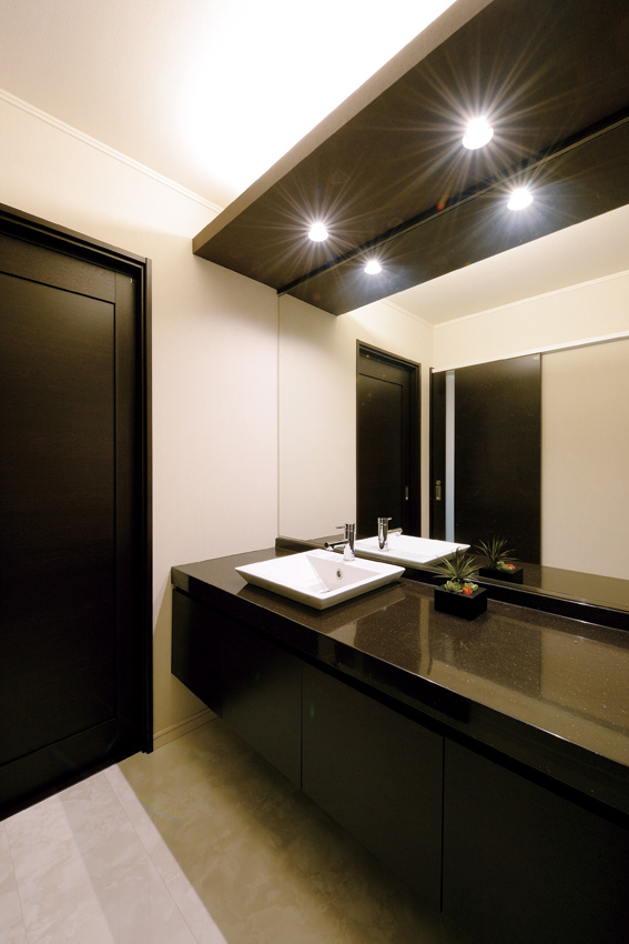 キッチンに隣接する洗面室は、モノトーンでまとめたラグジュアリーなスペース。パウダールームさながらのデザインが贅沢だ