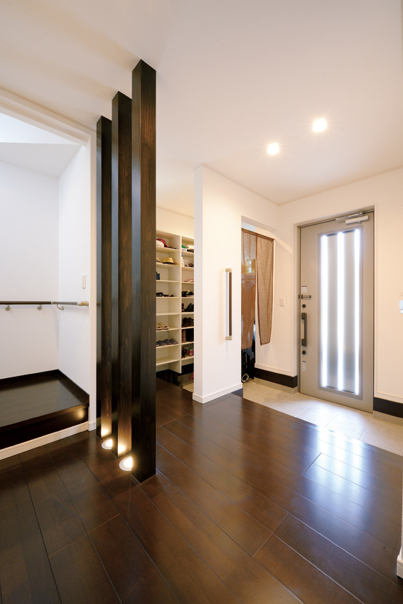 大容量の靴収納と家族用玄関を備えた玄関ホールは、ゆとりある広さが使いやすい。格子を下から照明で照らすなど、細かな部分まで丁寧に作り込まれている