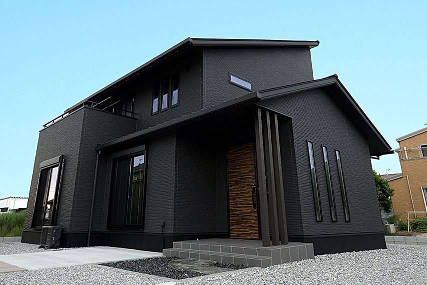 屋根や壁に加え、サッシや基礎まですべて黒く仕上げたオールブラックの住まい。凹凸感のあるデザインを採用することで、単色ながらもメリハリのある印象に