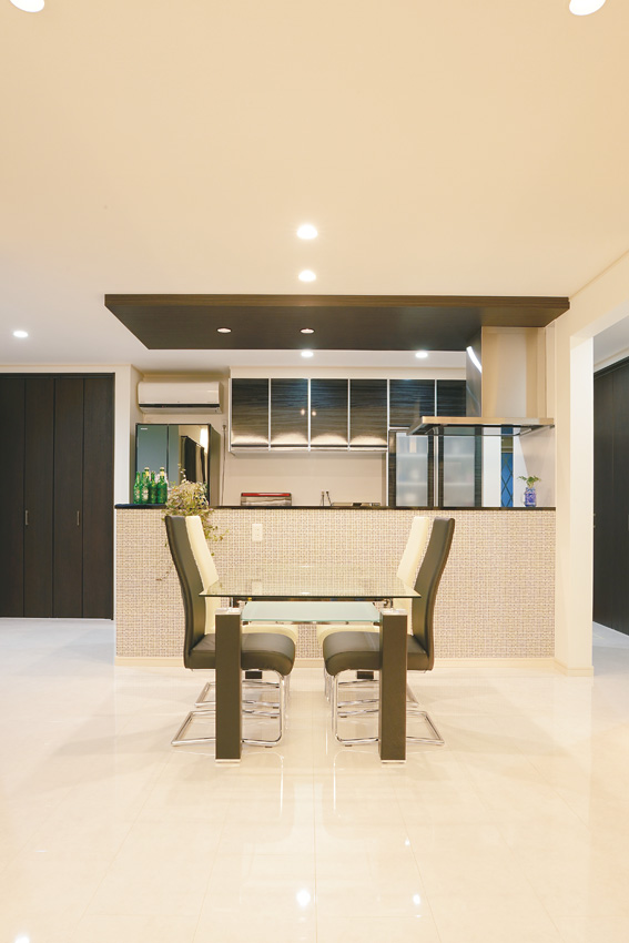シンプルな内装に、キッチンを覆うタイル調クロスがよく映える。キッチン背面収納やパントリーが豊富なため、生活感を感じさせるものはすっきりと隠せる